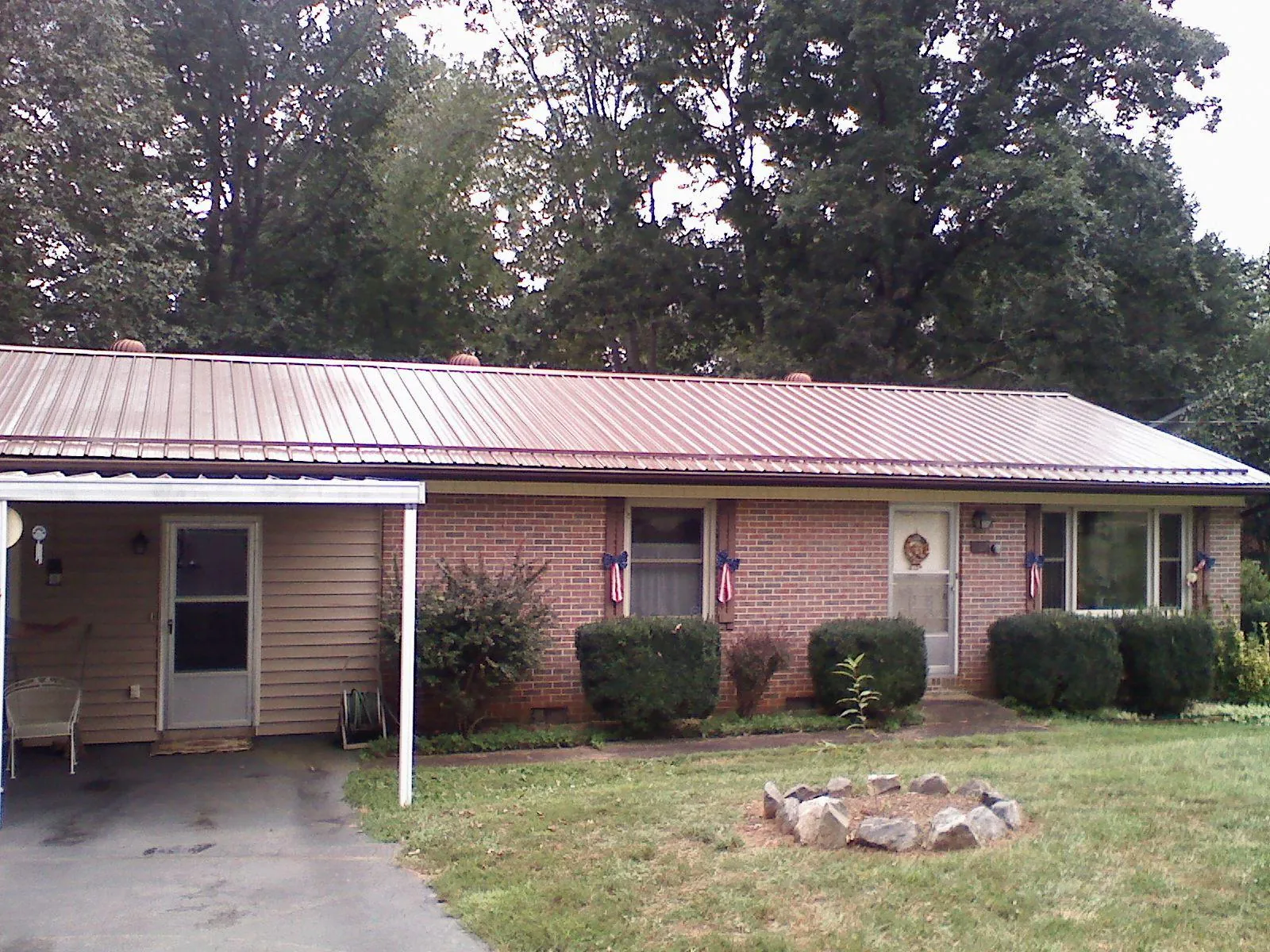 Bronze metal roof and carport on a brick ranch home — Roof Repair work by our crew in Malinta